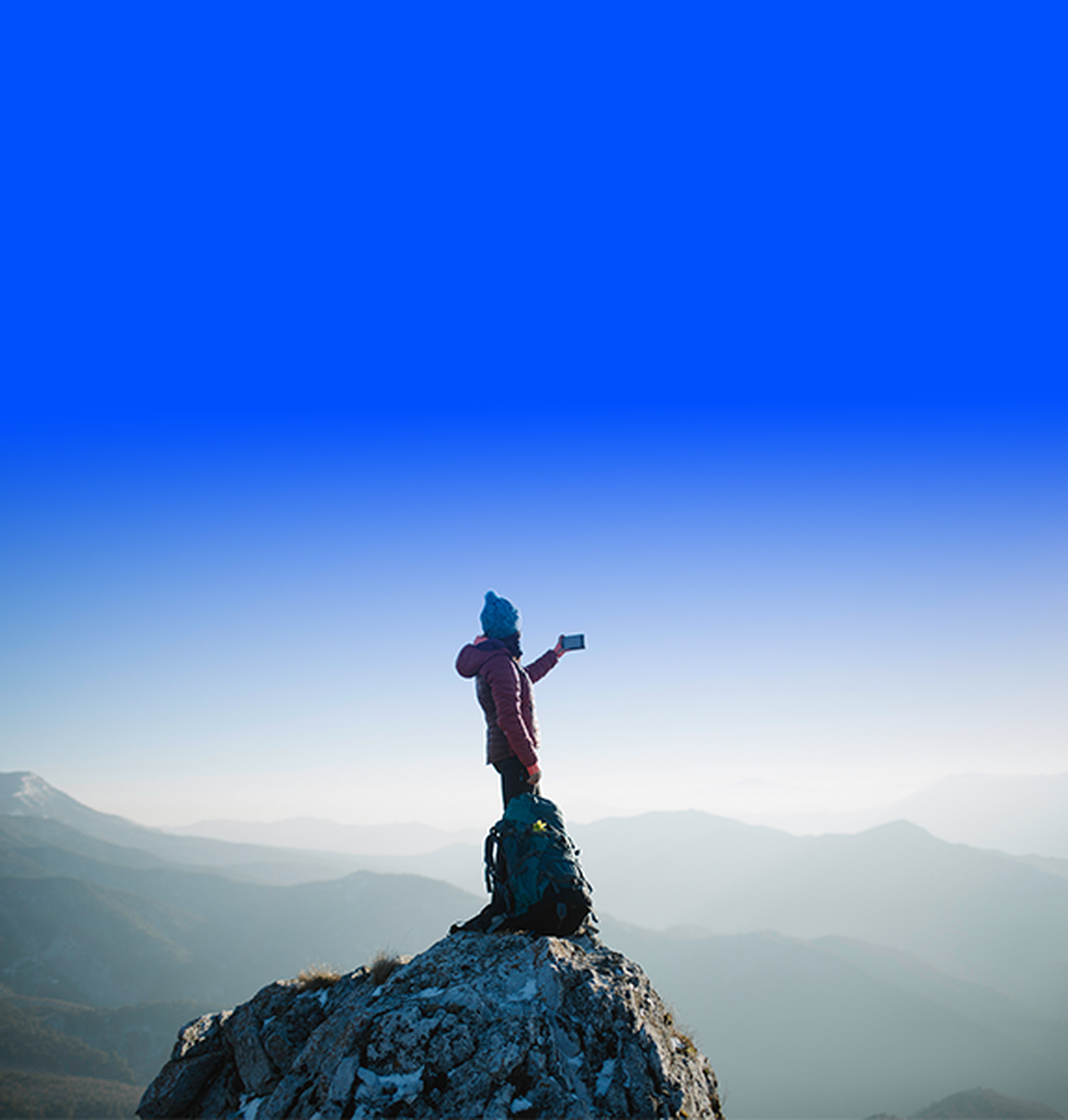 Person taking a picture with smartphone at mountain's summit