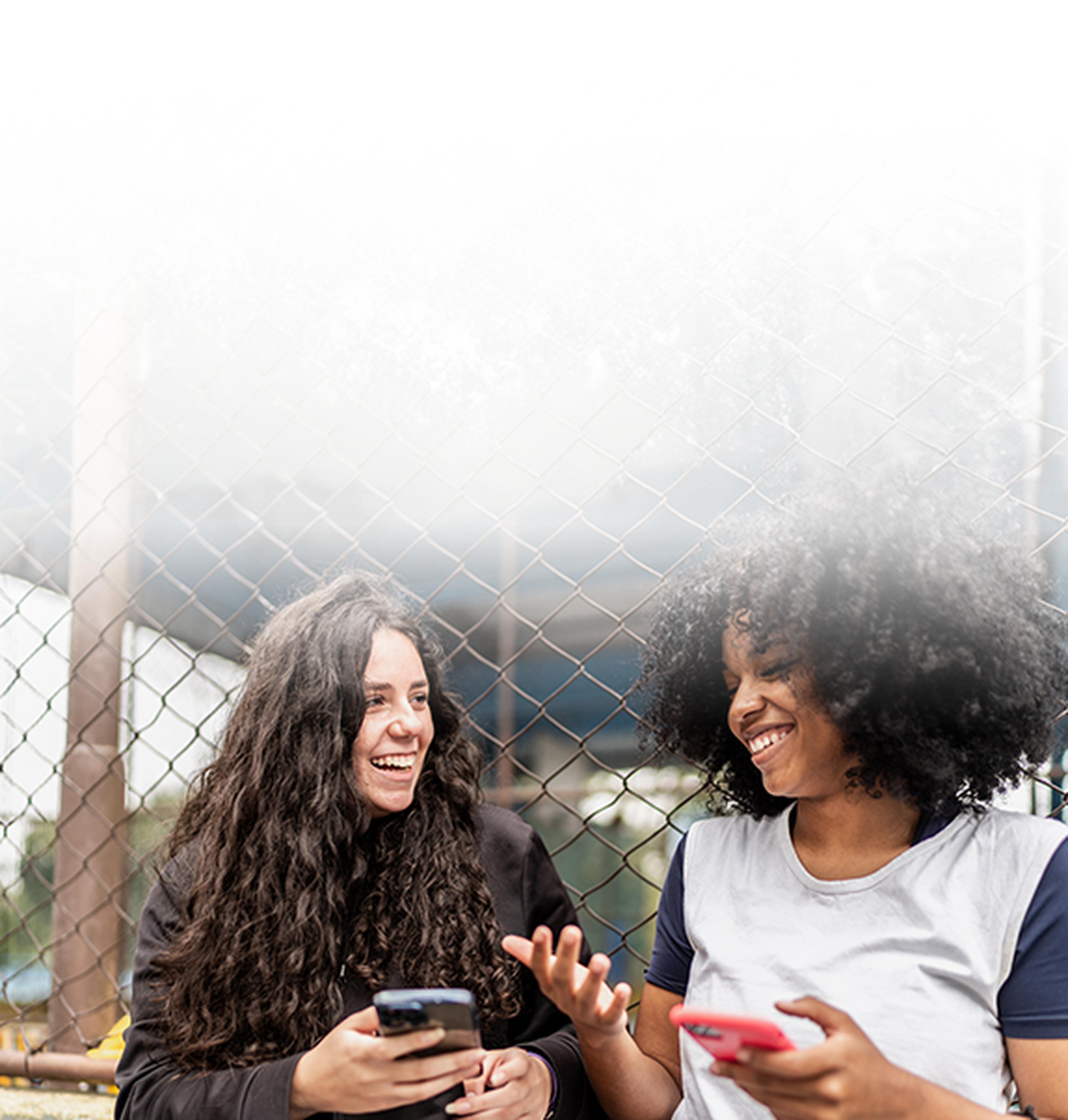 Two girls laughing and using phone