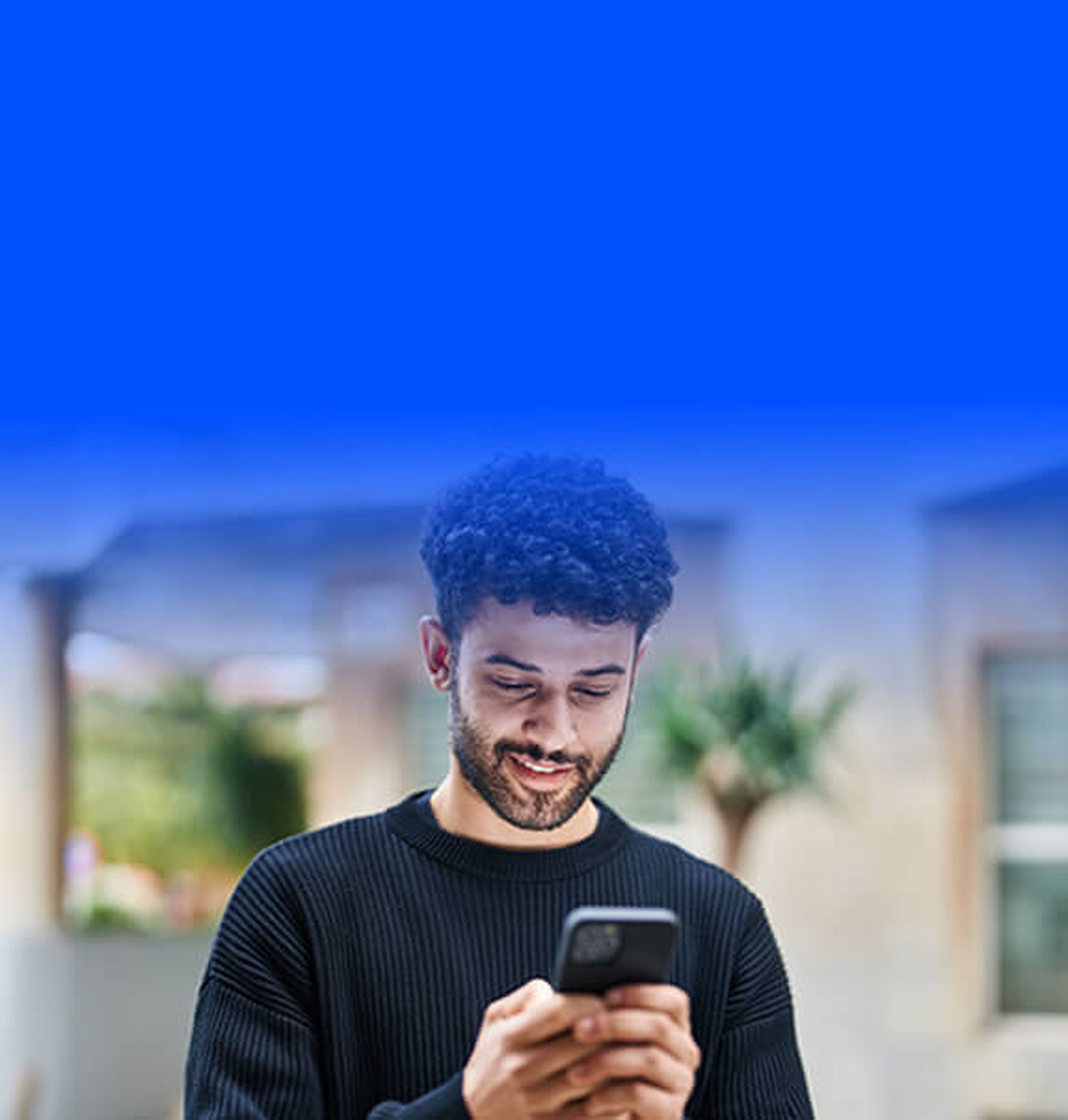 Man smiling and looking at phone