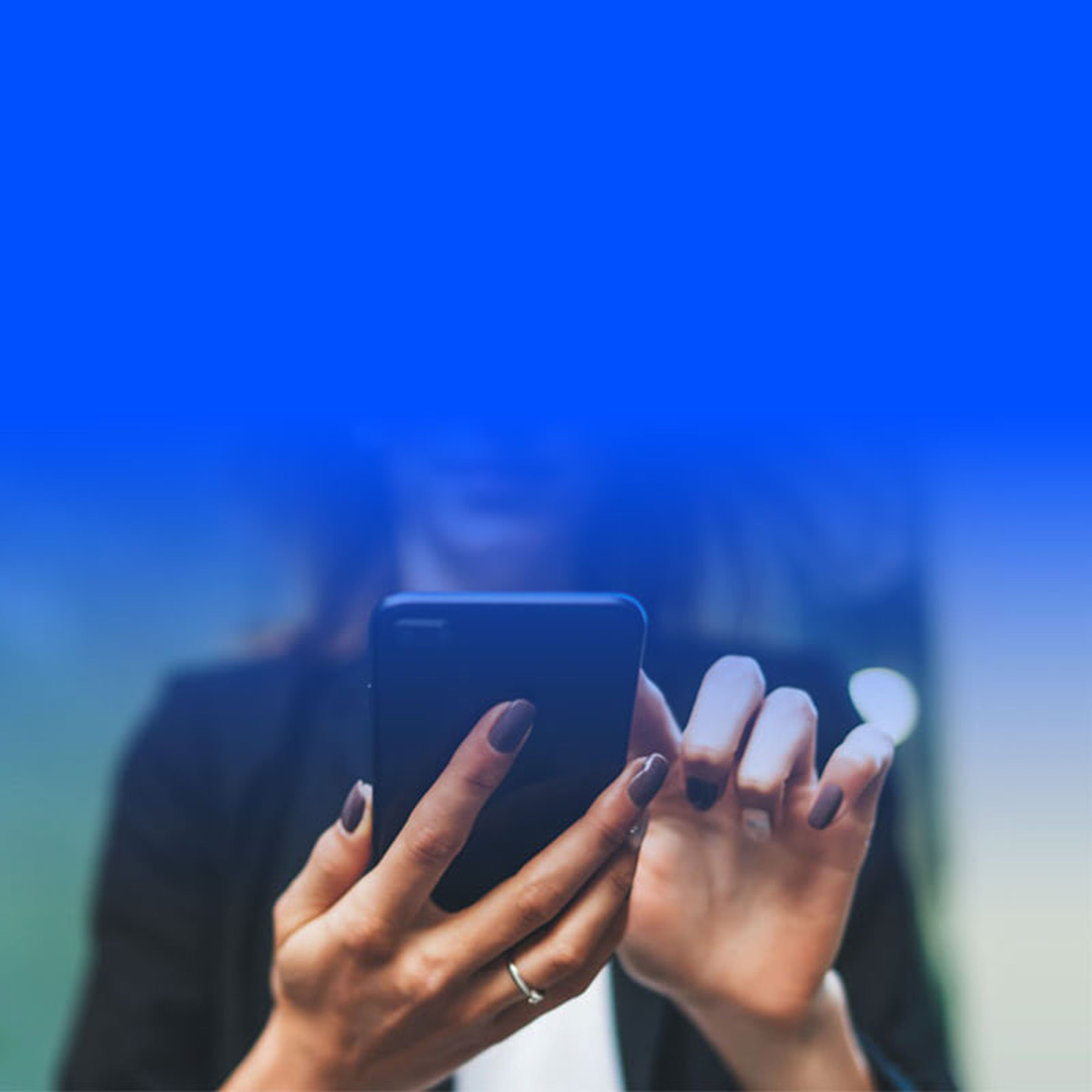 Woman looking down at phone in hand