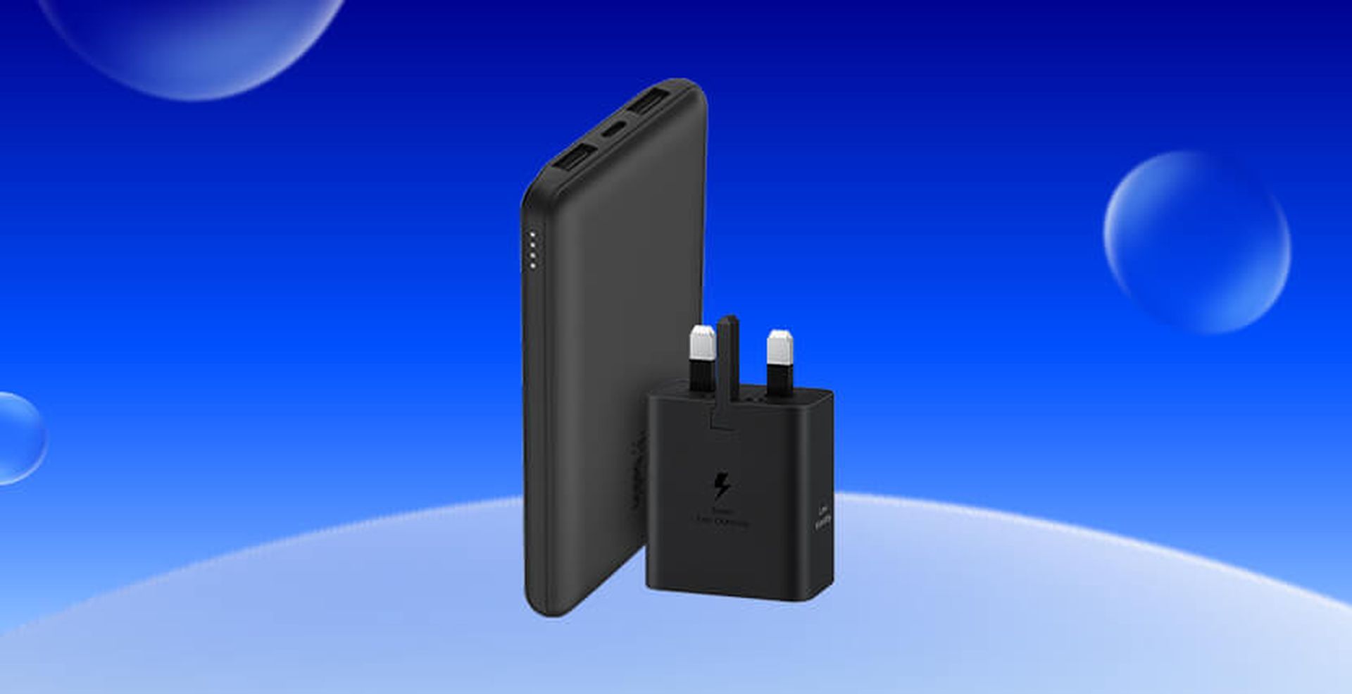 Black portable charger and wall adapter on a blue gradient background with bubbles.