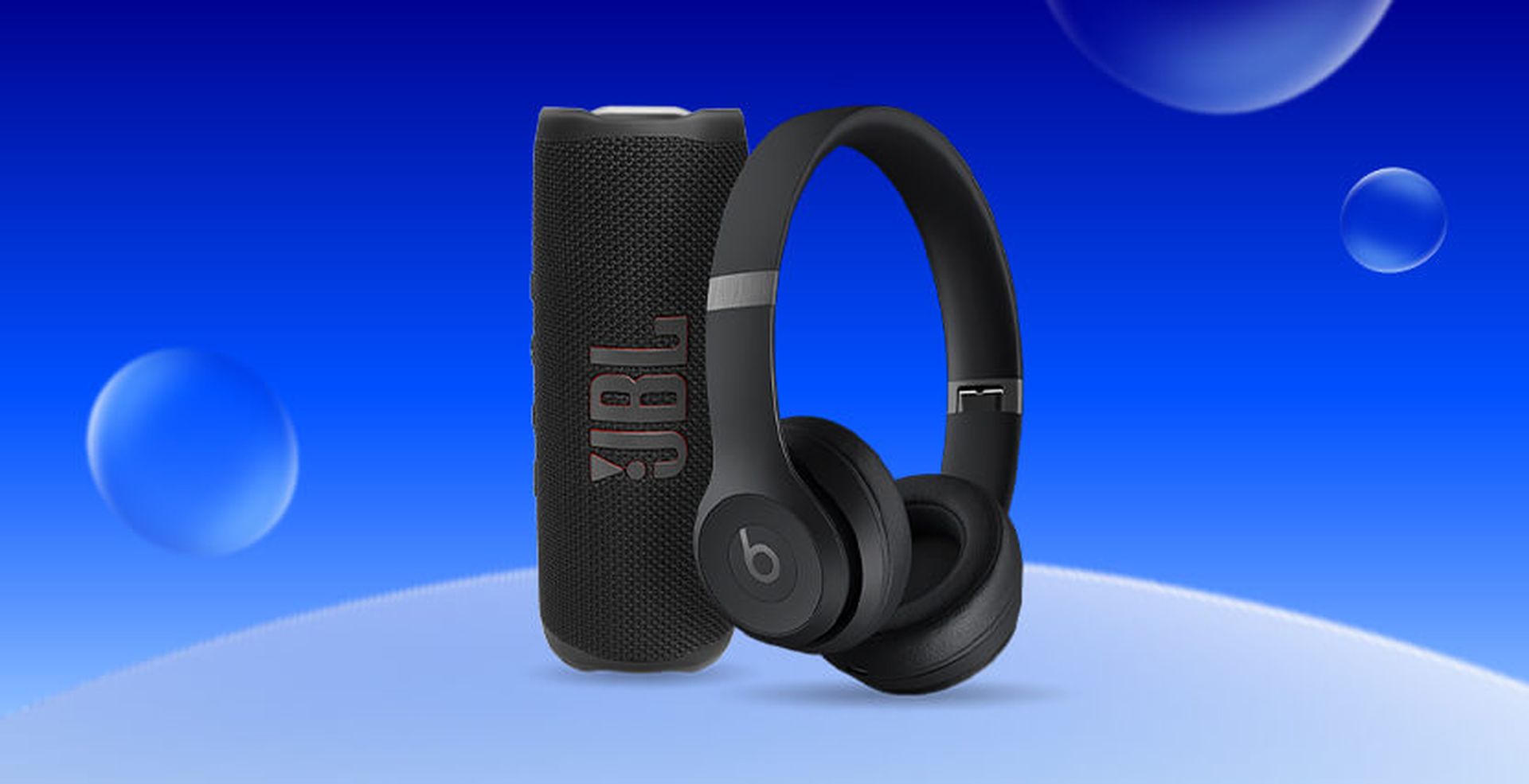 Black JBL speaker and black Beats headphones on a blue background with floating bubbles.